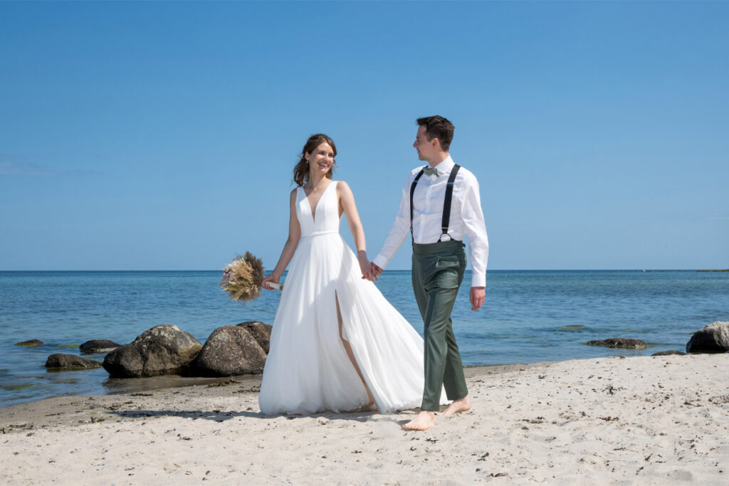 Nach der Trauung beginnt der gemeinsame Weg – barfuß im Sand, begleitet vom Licht der Ostsee. Dieses besondere Hochzeitsfotoshooting zeigt ein frisch vermähltes Paar beim Spaziergang am Strand von Binz. Die Ostsee im Hintergrund, das sanfte Licht und die natürliche Nähe schaffen eine Atmosphäre voller Ruhe, Romantik und Tiefe. Ein Moment, der nicht inszeniert, sondern gelebt wurde – authentisch eingefangen von Mazelle Photography. Ideal für Paare, die sich nach echten Emotionen und einem fotografischen Stil mit Seele sehnen.