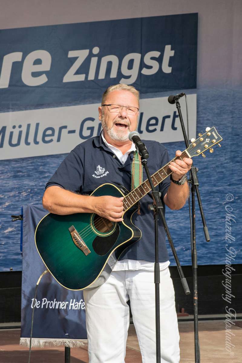 Der Gitarrist der Prohner Hafengäng in einem bewegenden Moment beim 27. Shantychöretreffen in Zingst. Die exklusive fotografische Begleitung durch Mazelle Photography Fotostudio® fängt die Atmosphäre zwischen maritimer Musik, Ostseelicht und gelebter Tradition ein. Auch der NDR berichtete über das Event – ein kulturelles Highlight mit Herz und Klang.